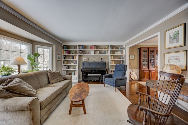 living room with ornamental molding, light wood-type flooring, and built in shelves