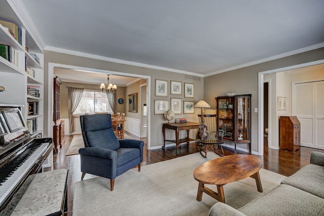 living room with crown molding, a notable chandelier, and hardwood / wood-style flooring