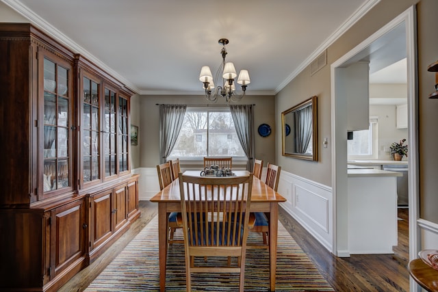 dining room with a notable chandelier, ornamental molding, and dark hardwood / wood-style floors