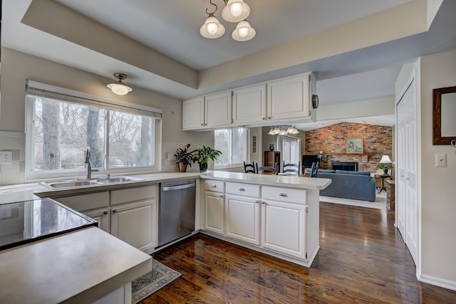 kitchen featuring white cabinetry, dishwasher, sink, a notable chandelier, and kitchen peninsula