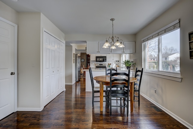 dining space featuring dark hardwood / wood-style floors and a notable chandelier