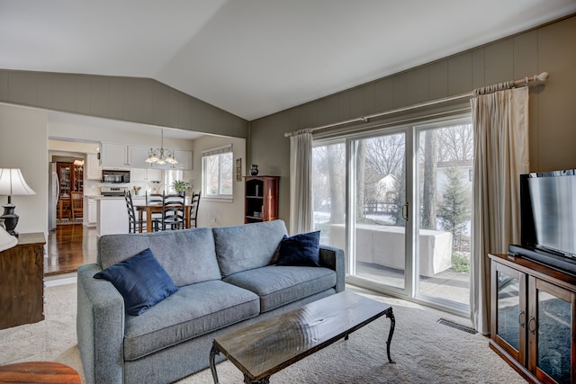 living room with an inviting chandelier and vaulted ceiling