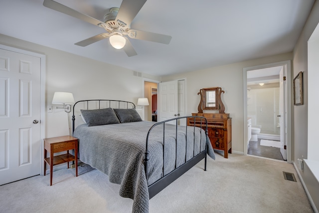 bedroom with connected bathroom, light colored carpet, and ceiling fan