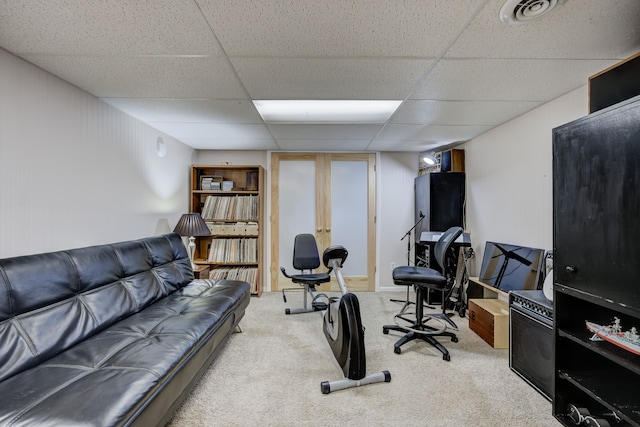 exercise area featuring light carpet and a drop ceiling