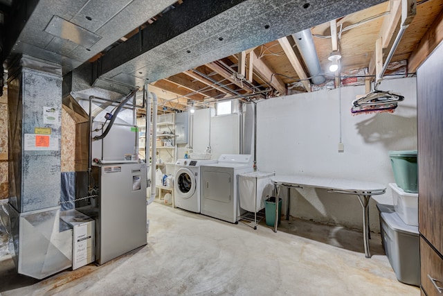 basement featuring washing machine and clothes dryer and heating unit