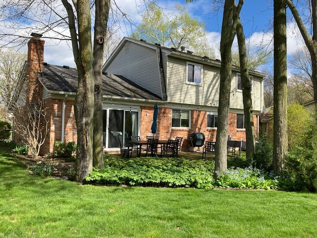 rear view of house featuring a yard