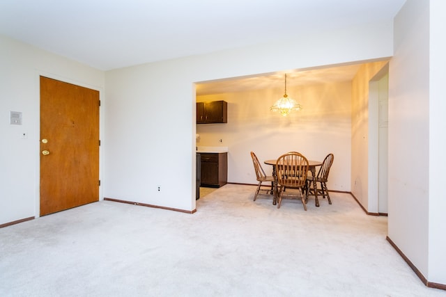 dining room featuring light carpet and a notable chandelier