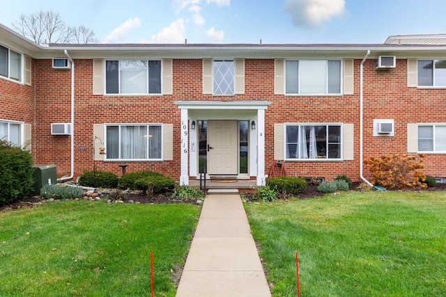 multi unit property featuring a front lawn and an AC wall unit