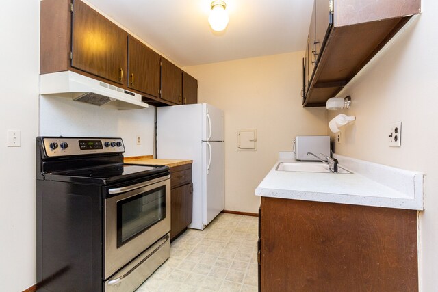 kitchen featuring sink, stainless steel electric stove, and white fridge