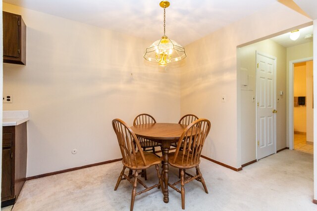 carpeted dining space featuring a notable chandelier