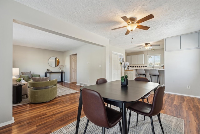 dining room with dark hardwood / wood-style floors and a textured ceiling