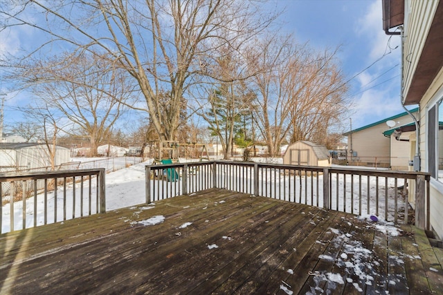 snow covered deck featuring a storage shed