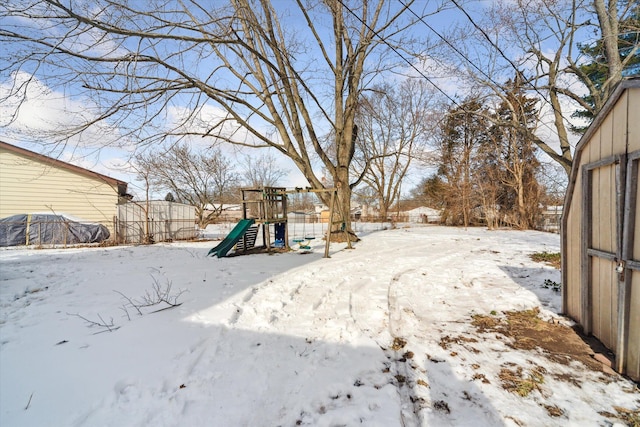 yard layered in snow with a playground