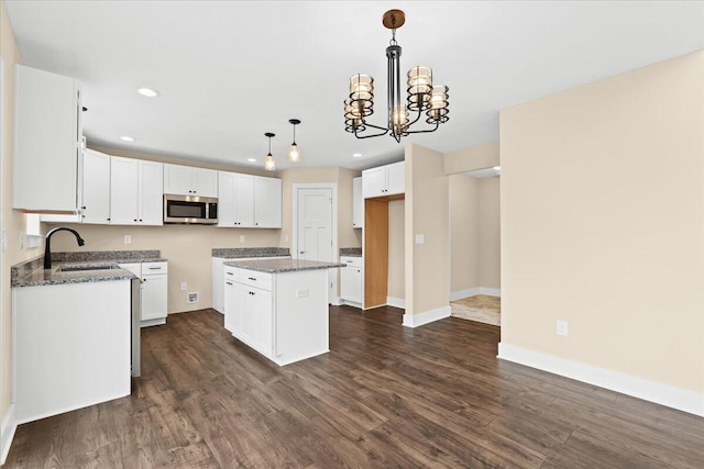 kitchen featuring sink, white cabinetry, dark stone countertops, dark hardwood / wood-style flooring, and a kitchen island