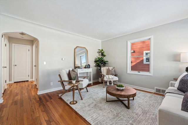 living room with dark hardwood / wood-style floors and a healthy amount of sunlight