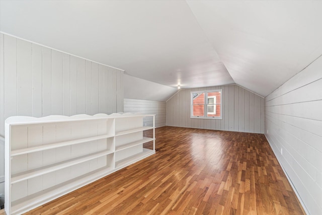 bonus room with hardwood / wood-style floors and vaulted ceiling