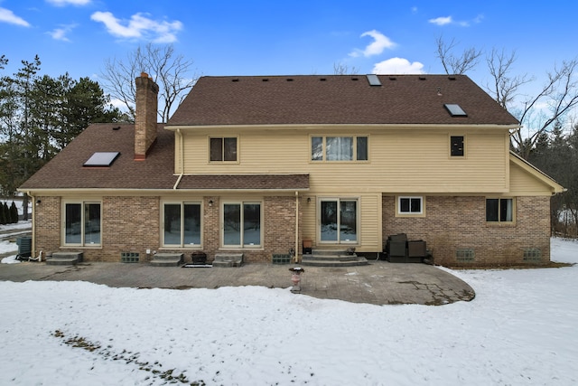 snow covered property with a patio area