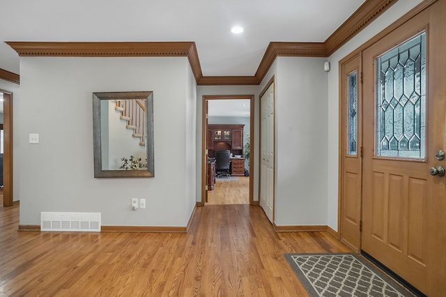 foyer entrance featuring crown molding and light hardwood / wood-style floors