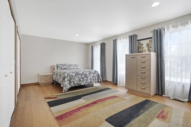 bedroom with baseboards, recessed lighting, and light wood-style floors
