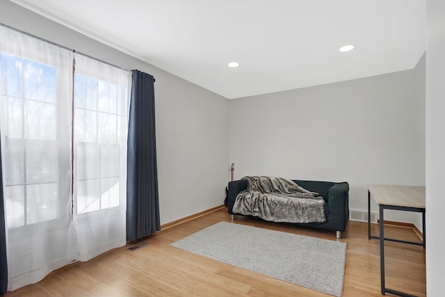 sitting room featuring baseboards, light wood-style floors, and visible vents