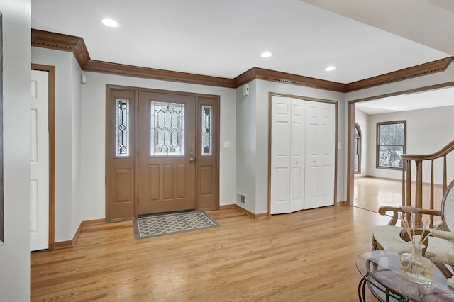 foyer featuring recessed lighting, baseboards, crown molding, and light wood-style flooring