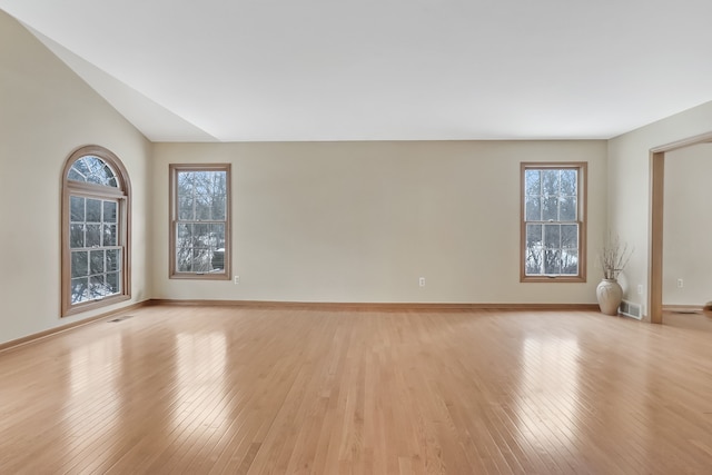 unfurnished room featuring lofted ceiling and light hardwood / wood-style floors