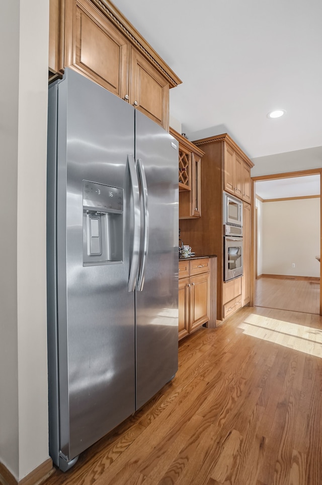 kitchen with light hardwood / wood-style flooring and appliances with stainless steel finishes