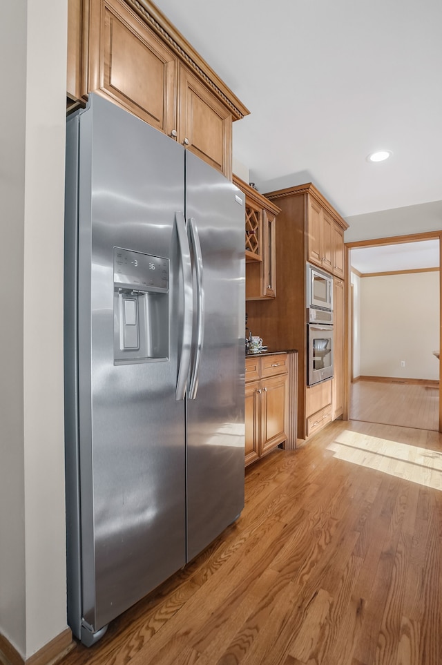 kitchen featuring light wood finished floors, stainless steel appliances, dark countertops, baseboards, and recessed lighting