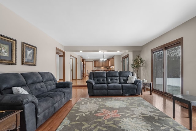 living room with a notable chandelier and light wood-type flooring