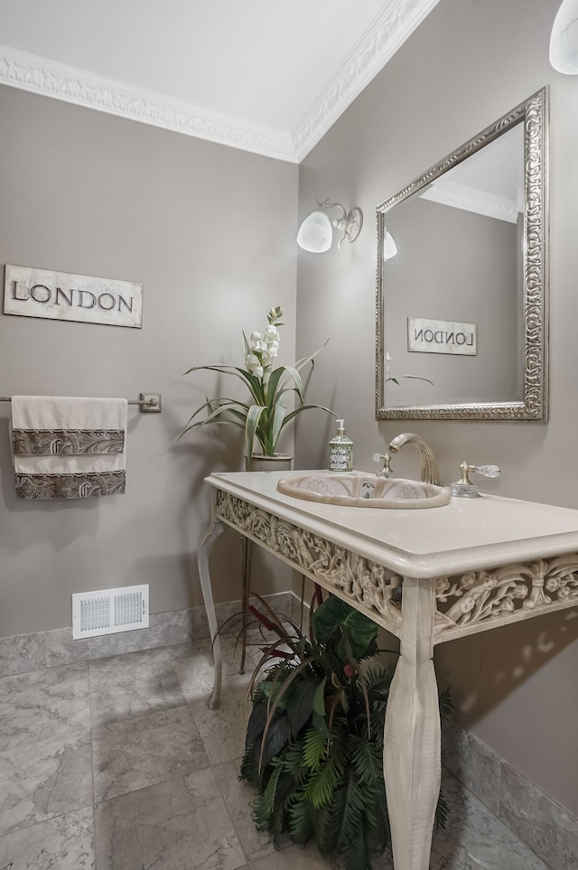 bathroom with ornamental molding and sink