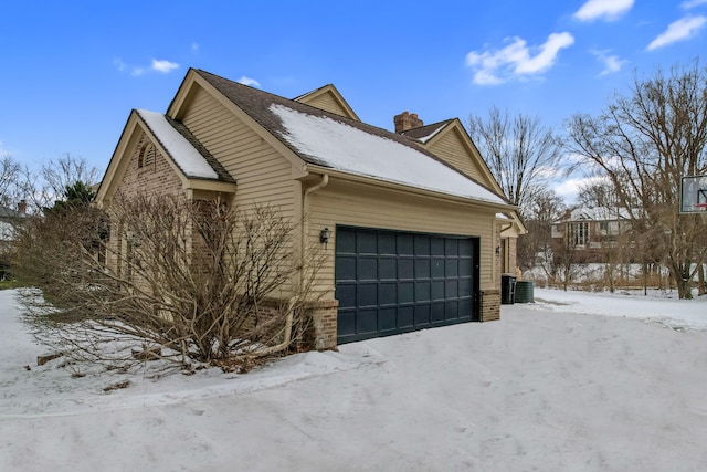 view of snow covered exterior with a garage