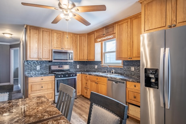 kitchen featuring sink, tasteful backsplash, stainless steel appliances, and light hardwood / wood-style floors