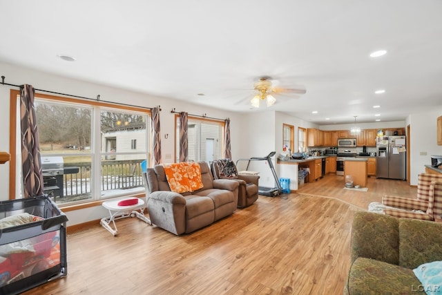 living room with light hardwood / wood-style flooring and ceiling fan