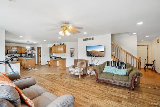 living room featuring ceiling fan and light hardwood / wood-style floors