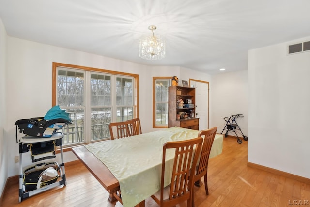 dining room with an inviting chandelier and light hardwood / wood-style floors