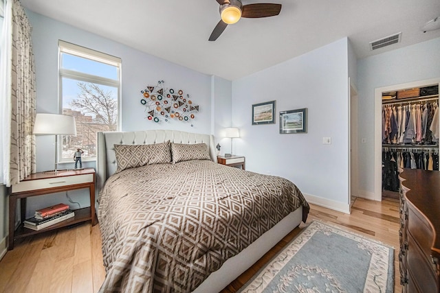 bedroom with ceiling fan, a closet, and light hardwood / wood-style flooring