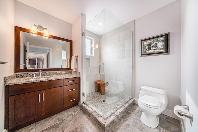 bathroom with vanity, a shower with door, and toilet