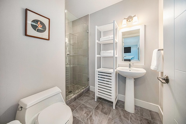 bathroom featuring an enclosed shower, sink, and toilet