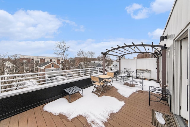 snow covered deck with a pergola