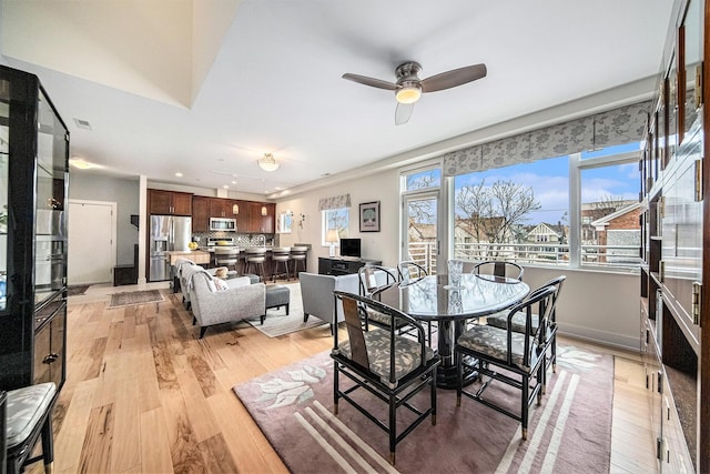 dining area with ceiling fan and light wood-type flooring