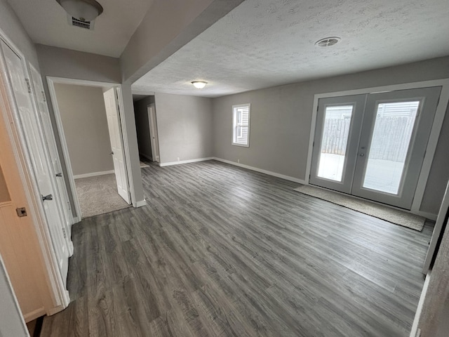 interior space with dark wood-type flooring, french doors, and a textured ceiling