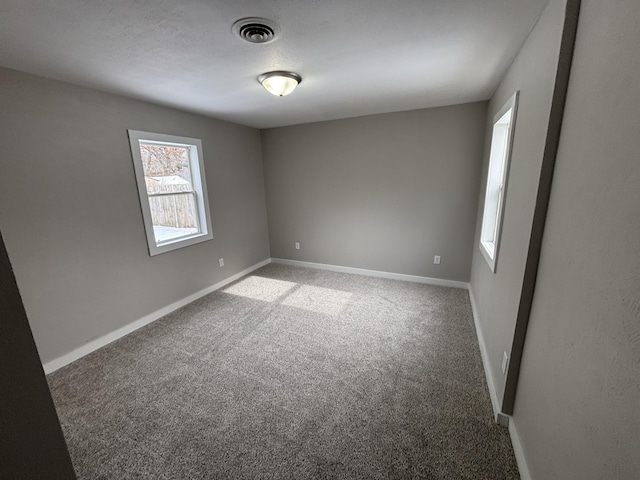 empty room featuring a textured ceiling and carpet flooring