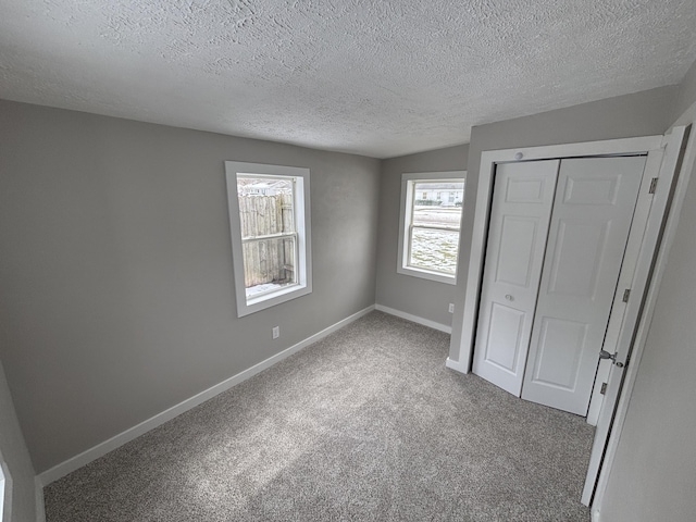 unfurnished bedroom featuring carpet flooring, a textured ceiling, and a closet