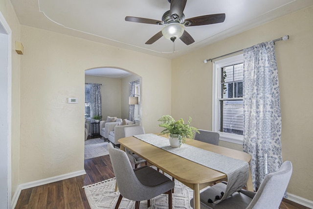 dining area with dark wood-type flooring and ceiling fan