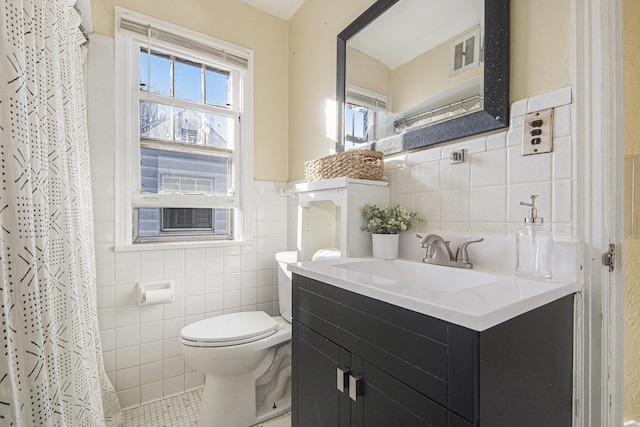 bathroom with vanity, a wealth of natural light, tile walls, and toilet