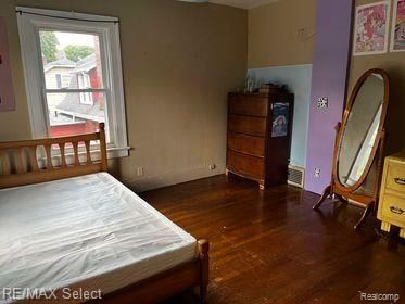 bedroom with dark hardwood / wood-style flooring