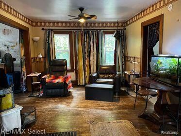 sitting room with ceiling fan, a healthy amount of sunlight, and dark hardwood / wood-style flooring