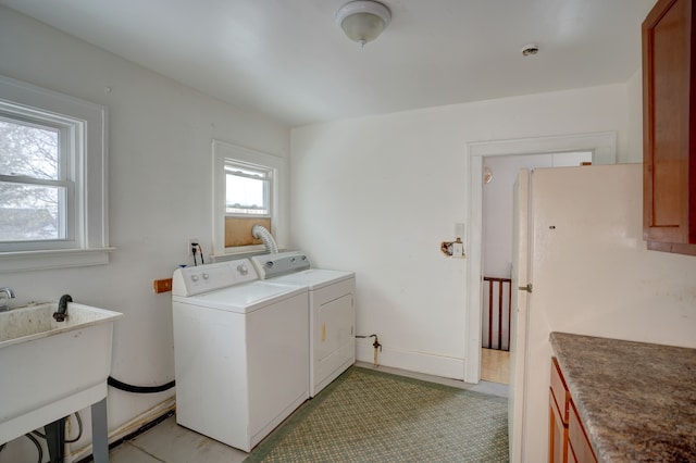 laundry area featuring cabinets, sink, and washer and dryer