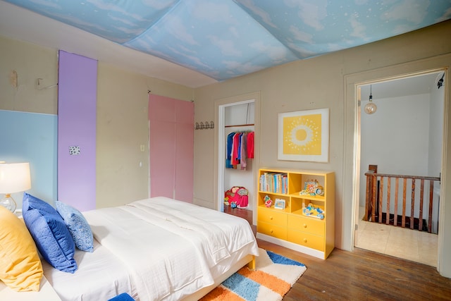 bedroom with dark wood-type flooring and a closet