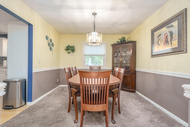 carpeted dining area featuring an inviting chandelier